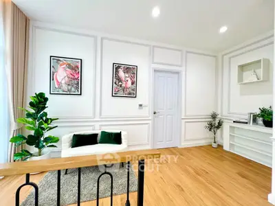 Elegant living room with modern decor, wooden flooring, and stylish wall art, perfect for cozy gatherings.