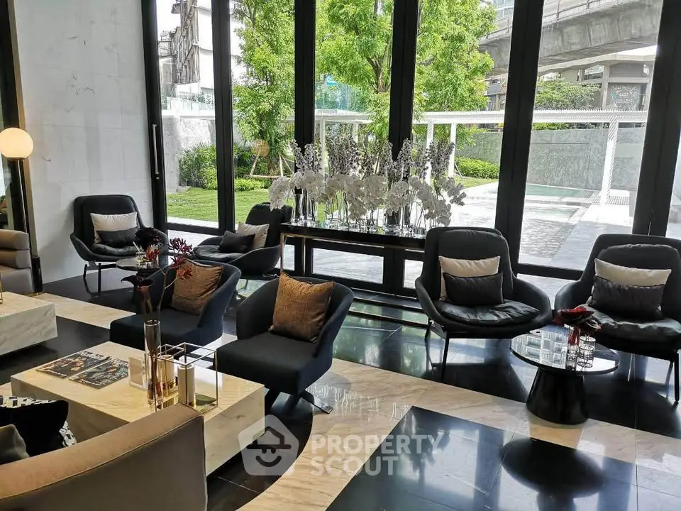 Luxurious modern lobby with elegant seating and large windows overlooking lush greenery.