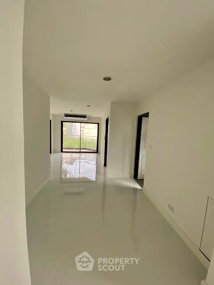 Spacious modern apartment hallway with glossy floors and large windows