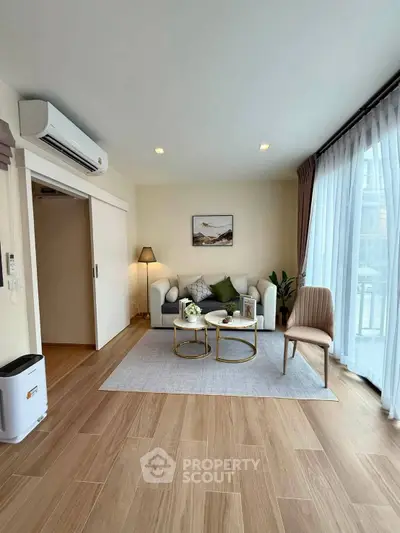 Modern living room with large windows and stylish decor in a cozy apartment.