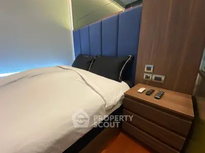 Modern bedroom with sleek design and cozy bedding in a stylish apartment.