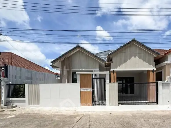 Charming single-story house with modern facade and gated entrance in a serene neighborhood.