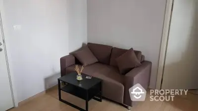 Cozy small living room with modern sofa and coffee table in minimalist design.