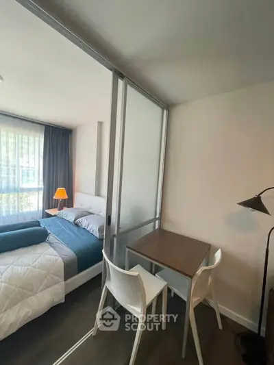 Modern bedroom with sliding glass partition and cozy study area