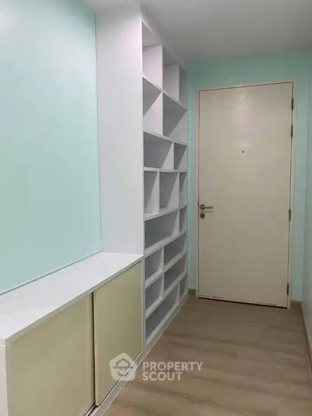 Modern minimalist hallway with built-in shelving and light wood flooring.
