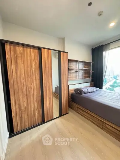Modern bedroom with wooden wardrobe and city view window, perfect for urban living.