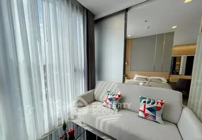 Modern living room with stylish decor and city view, featuring a cozy sofa and elegant curtains.