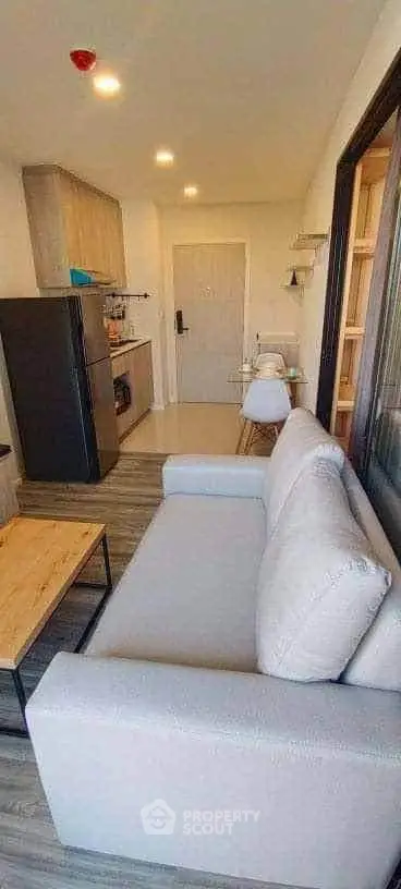 Modern apartment interior with cozy living area and compact kitchen, featuring sleek furniture and stylish decor.