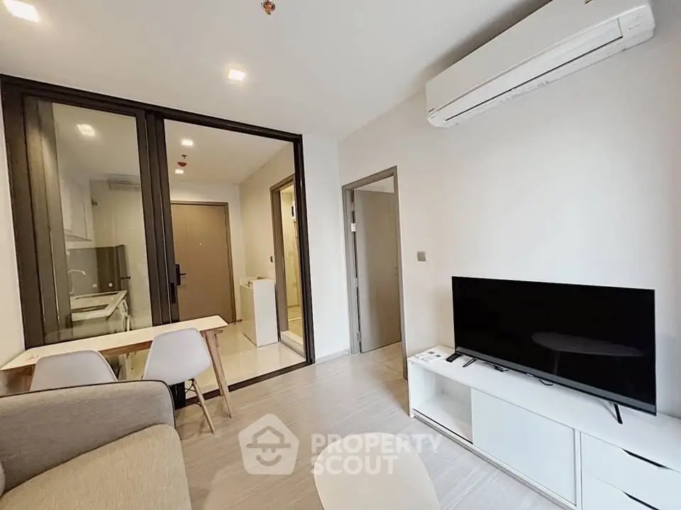 Modern living room with sleek furniture and open kitchen layout in a stylish apartment.
