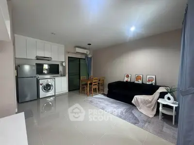 Modern living room with sleek kitchen, dining area, and cozy seating, perfect for urban living.