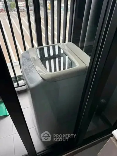 Modern washing machine on a balcony with city view, perfect for urban living convenience.