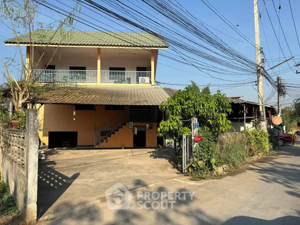 Charming two-story house with spacious balcony and lush greenery in a serene neighborhood.