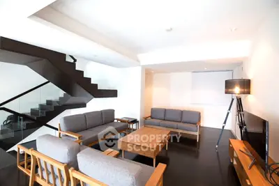 Modern living room with stylish furniture and sleek staircase design