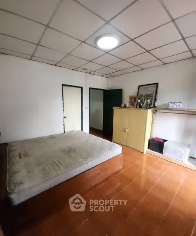 Spacious bedroom with minimalist decor and ample natural light