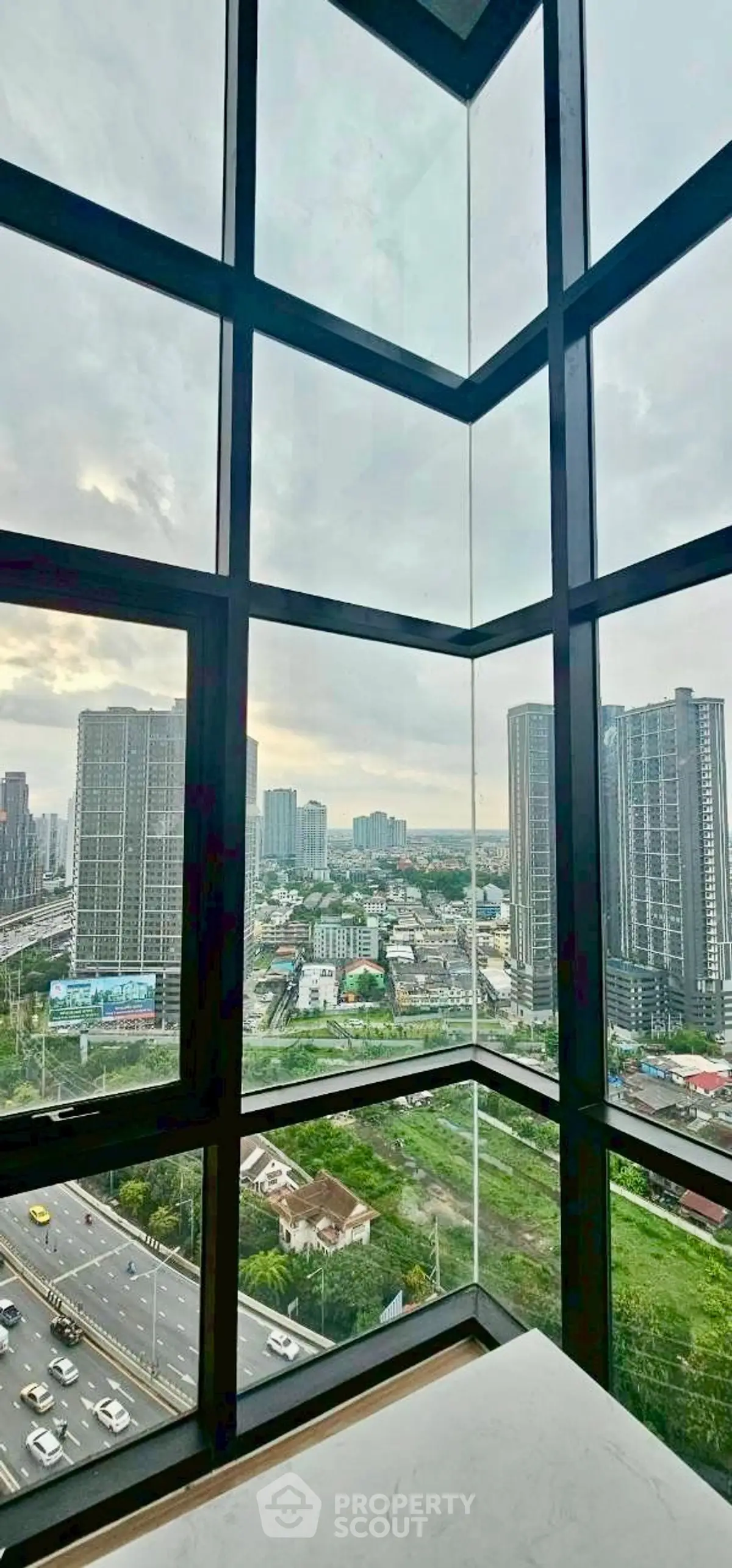 Stunning cityscape view from high-rise building window, showcasing urban skyline and vibrant city life.