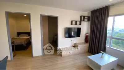 Modern living room with TV, wooden flooring, and large window view