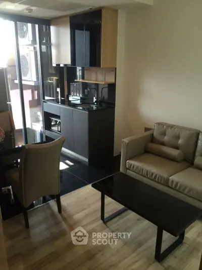 Modern open-plan living room with sleek kitchen and cozy seating area.