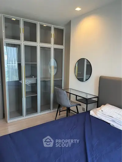 Modern bedroom with stylish glass wardrobe and sleek study desk, perfect for urban living.