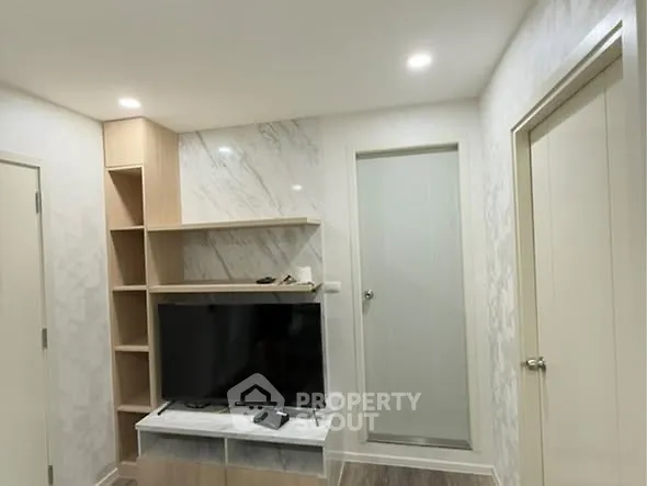 Modern living room with sleek TV setup and stylish shelving.