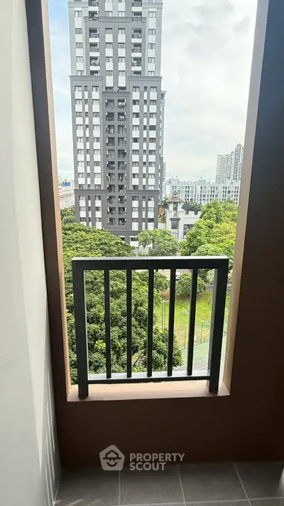 Stunning cityscape view from a modern apartment balcony, showcasing lush greenery and urban architecture.