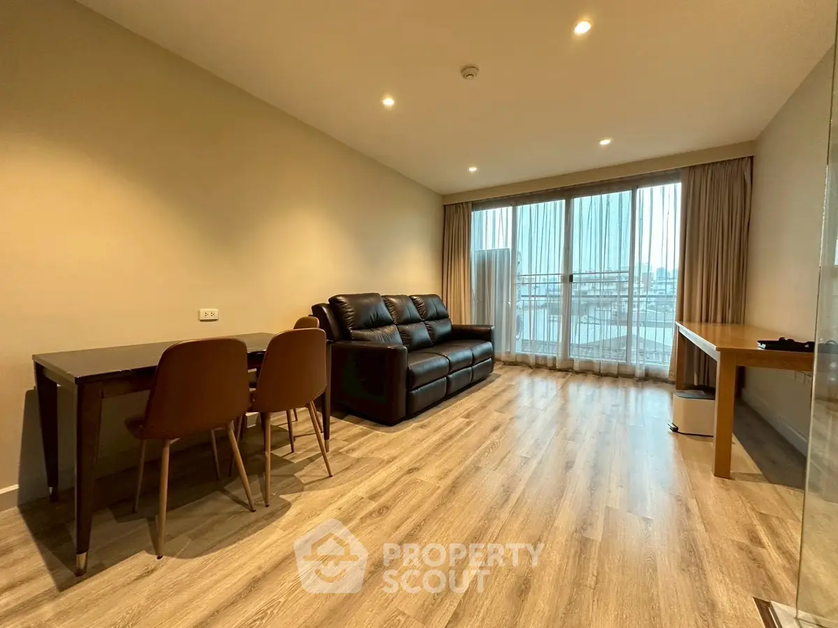 Spacious modern living room with wooden flooring and balcony view