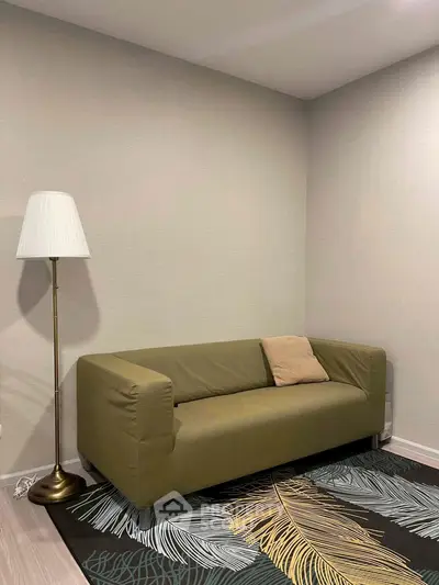 Modern living room with stylish green sofa and elegant floor lamp on a chic patterned rug.