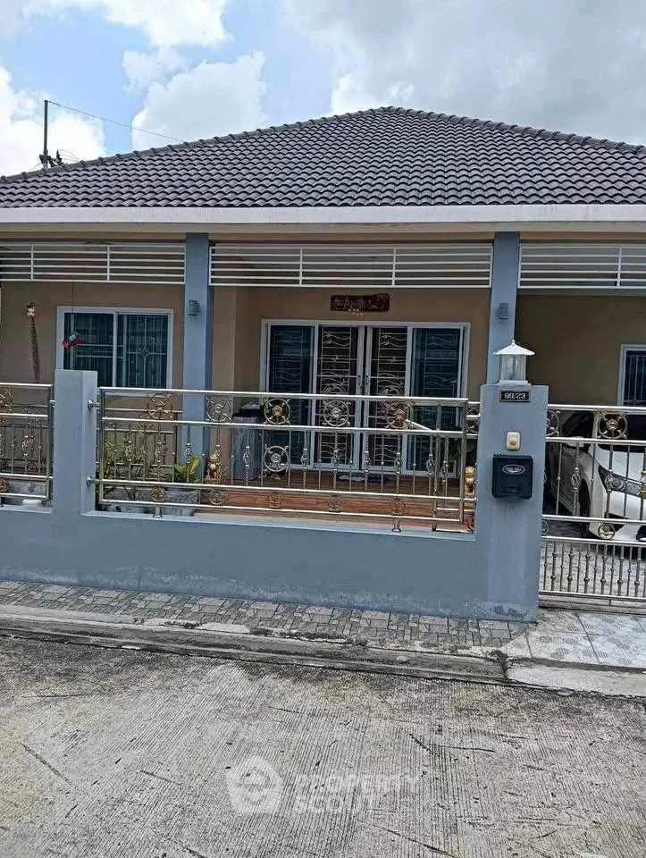 Charming single-story home with tiled roof and gated entrance, perfect for modern living.