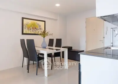 Modern dining area with sleek table and chairs, open kitchen layout, and stylish decor.