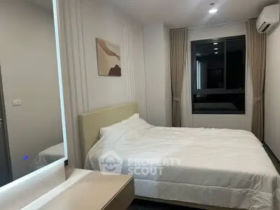 Modern bedroom with stylish decor and large window in a contemporary apartment.