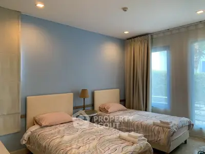 Cozy twin bedroom with soft lighting and modern decor, perfect for a relaxing stay.