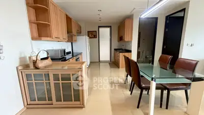 Spacious kitchen with dining area featuring modern appliances and elegant wooden cabinetry.