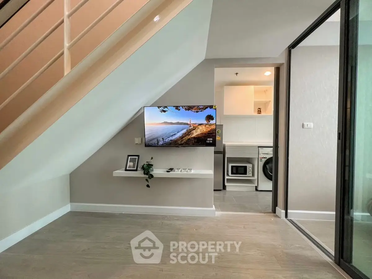 Modern interior with under-stair TV setup and laundry area, sleek design