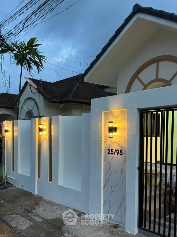 Charming suburban home with elegant exterior lighting and secure gated entrance.