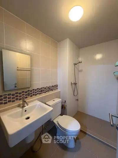 Modern bathroom with sleek fixtures and a spacious shower area.