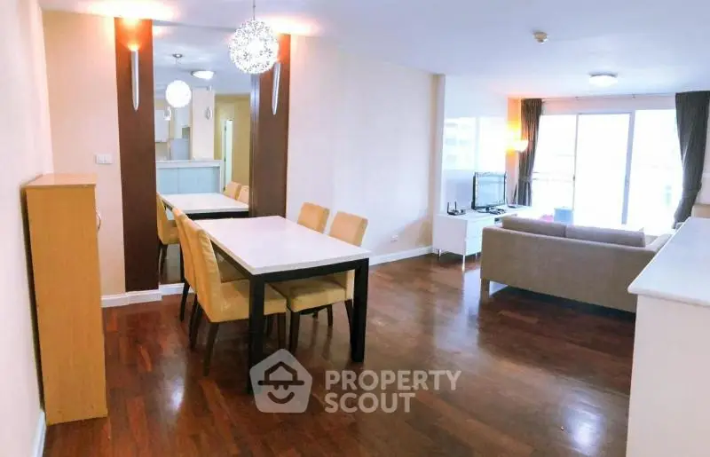 Spacious open-plan living and dining area with modern furnishings and hardwood floors.