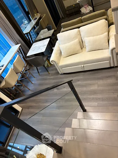 Modern living room with stylish furniture and sleek staircase in a contemporary apartment.