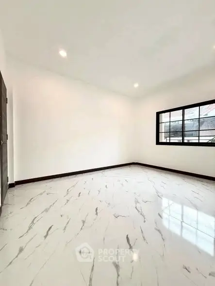 Spacious empty room with marble flooring and large window