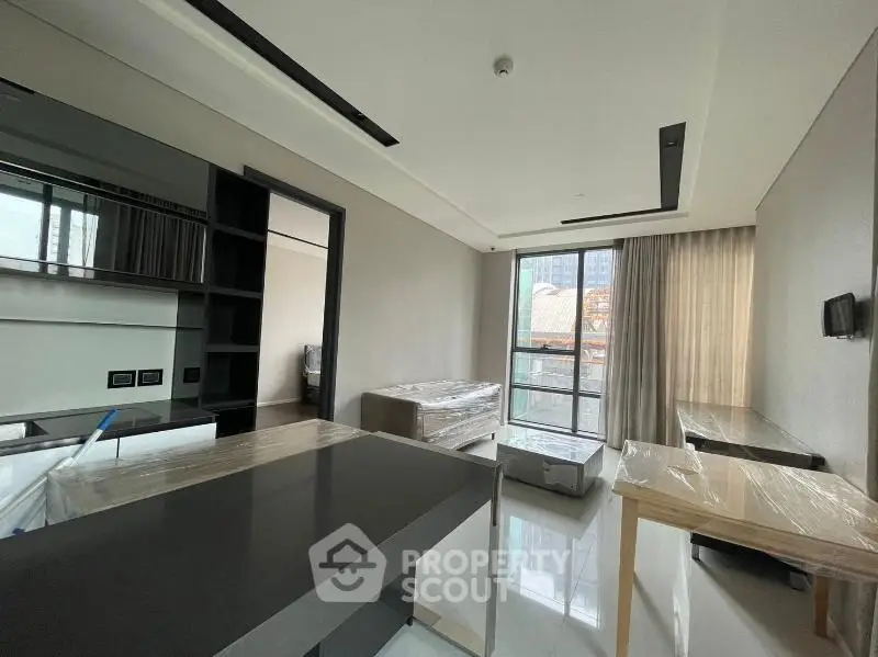 Modern living room with sleek design and large windows offering city views.