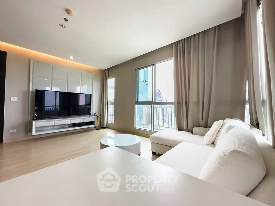 Spacious modern living room with large windows and elegant white furniture