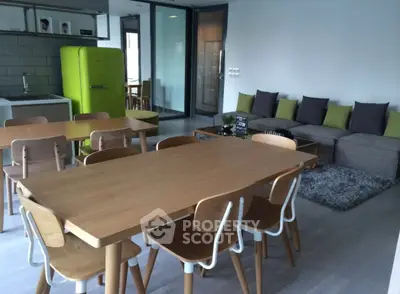 Modern open-plan living room with dining area and vibrant green fridge