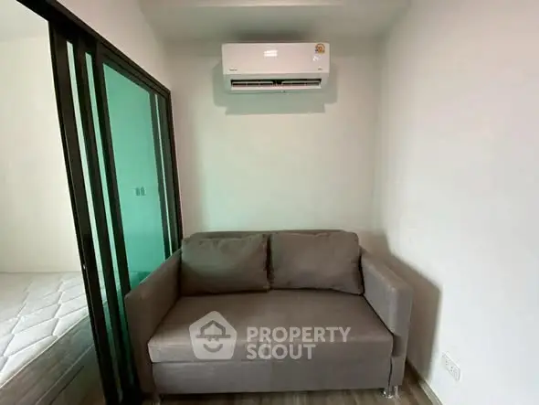Cozy living area with modern air conditioning and compact sofa, perfect for small apartments.
