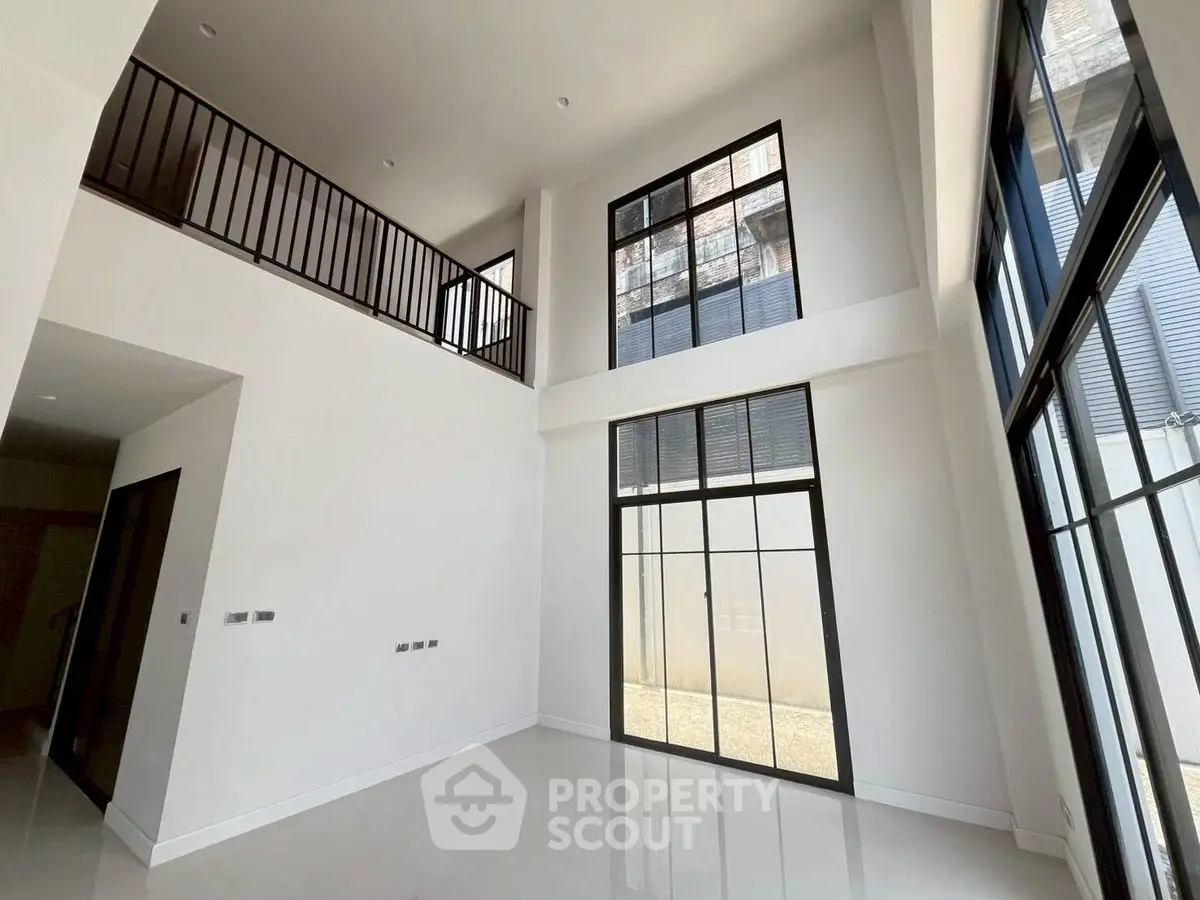Spacious modern living room with high ceilings and large windows for natural light.