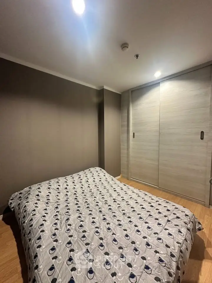 Cozy bedroom with modern decor and ample closet space in a stylish apartment.
