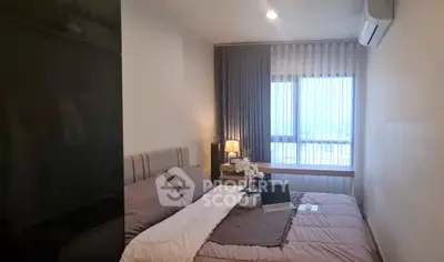 Cozy bedroom with modern decor and large window offering natural light.