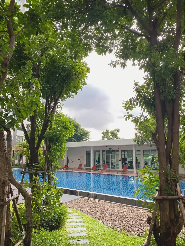 Luxurious residential pool surrounded by lush greenery and modern architecture, perfect for relaxation and leisure.