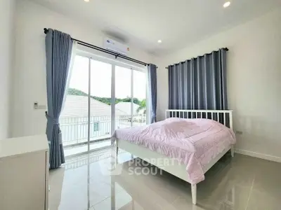 Bright and airy bedroom with large windows and modern decor in a stylish home.