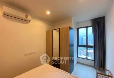 Modern bedroom with city view, featuring air conditioning and sleek wardrobe design.