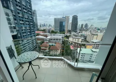 Stunning city view from modern high-rise balcony with stylish outdoor seating.