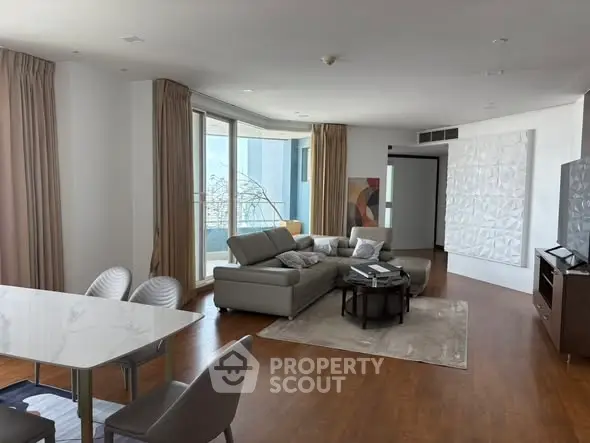 Spacious modern living room with elegant decor and large windows offering natural light.