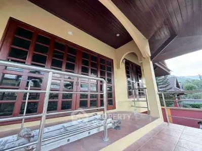 Charming house exterior with wooden windows and tiled porch, perfect for relaxation.